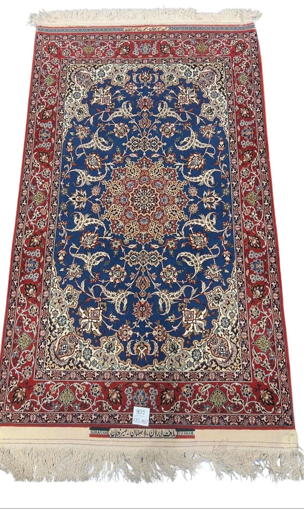 Hand-knotted Persian Seirafian rug with a deep blue medallion and red border.
